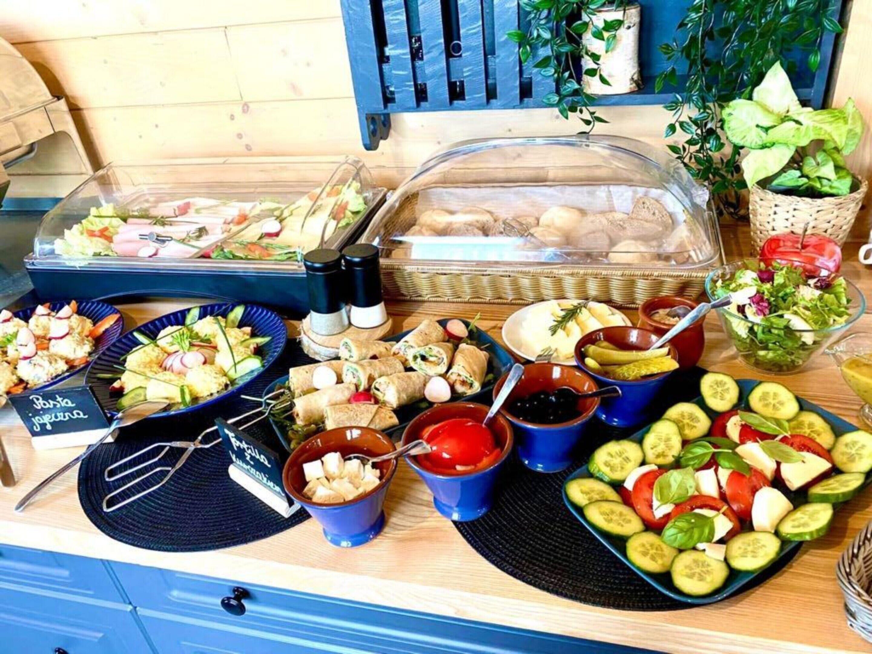 A buffet with various food items including salads, sandwiches, and fruit.
