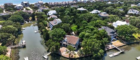 An aerial view of a residential area with houses, a river, and a dock.
