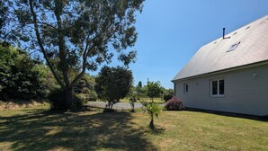 A residential property with a house, a large tree, and a well-maintained lawn.