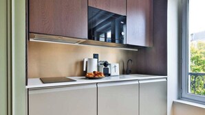 A compact kitchen with a built-in microwave, a coffee maker, and a toaster on the countertop. - Modern Apartment - 1br/4p - Canal St-martin (Paris)