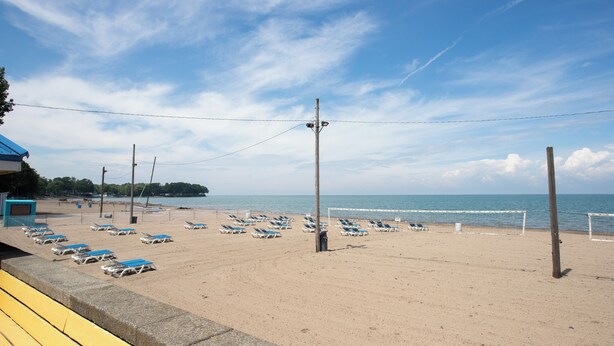 A beach with sun loungers and a volleyball net. - Lakeside Bliss- Close to Highmark Stadium, home of the Bills! (Angola)