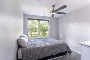 A bedroom with a bed, a window, a ceiling fan, and a white dresser. - Lakeside Bliss- Close to Highmark Stadium, home of the Bills! (Angola)