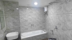 Une salle de bain avec une baignoire, un lavabo et une douche.