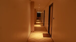 Un pasillo largo y estrecho con suelo de madera e iluminación empotrada.