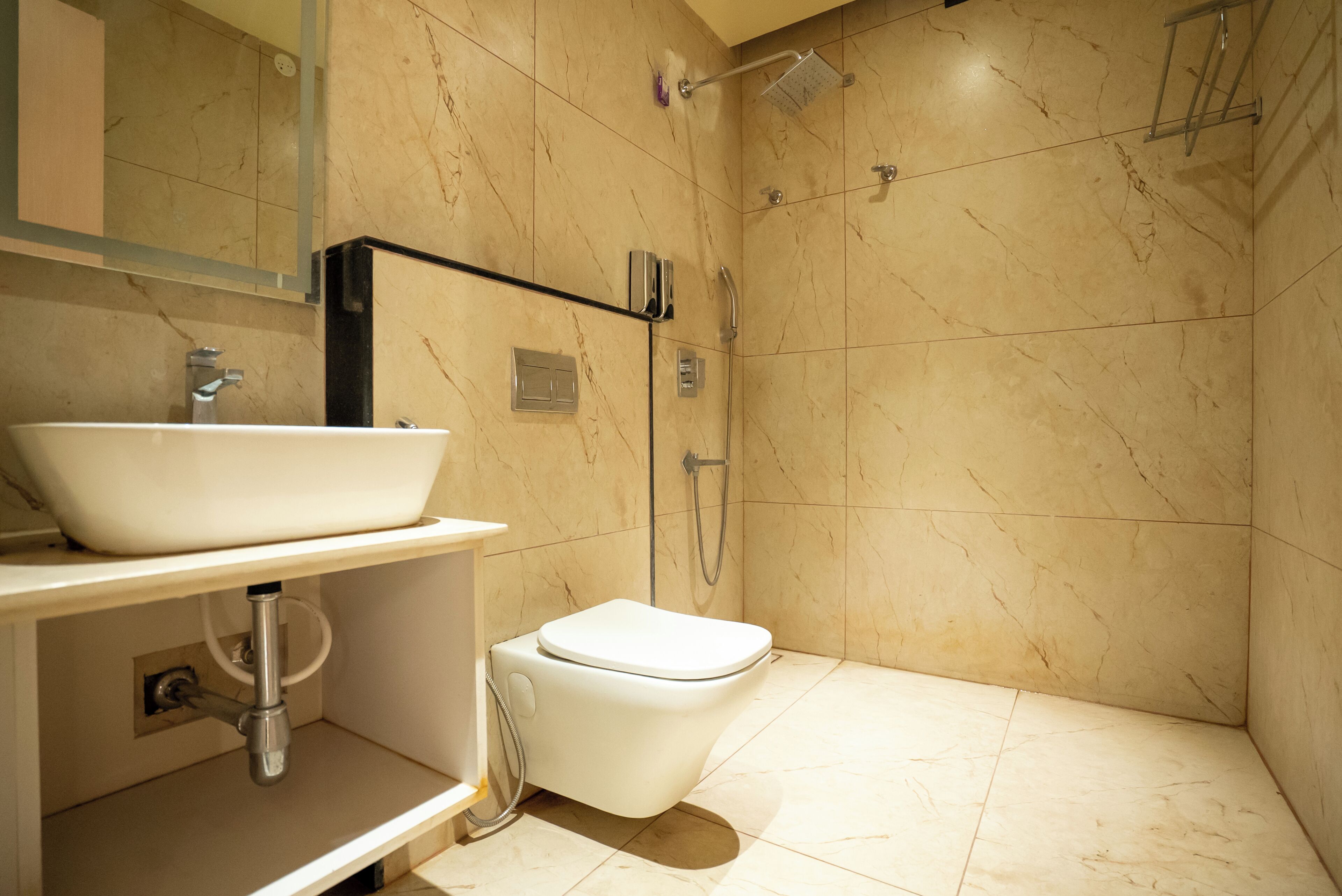 Un baño con lavamanos blanco, inodoro y zona de ducha.
