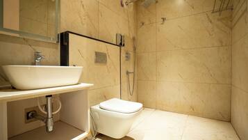 Un baño con lavamanos blanco, inodoro y zona de ducha.