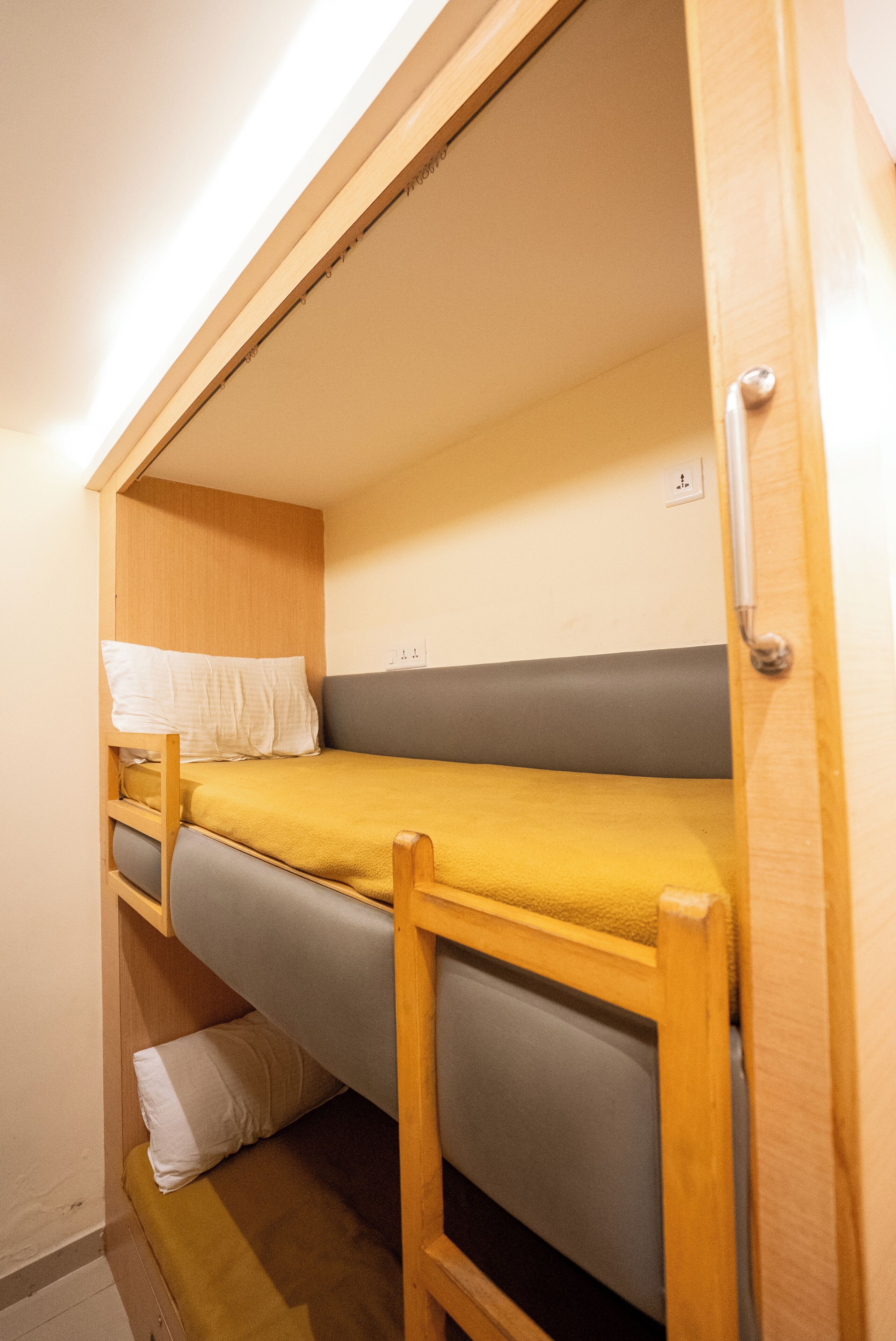 Ein Stockbett aus Holz mit einer Matratze und einem Kopfkissen.
