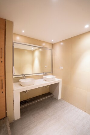 Un baño moderno con dos lavamanos, un espejo grande y un mueble de madera.