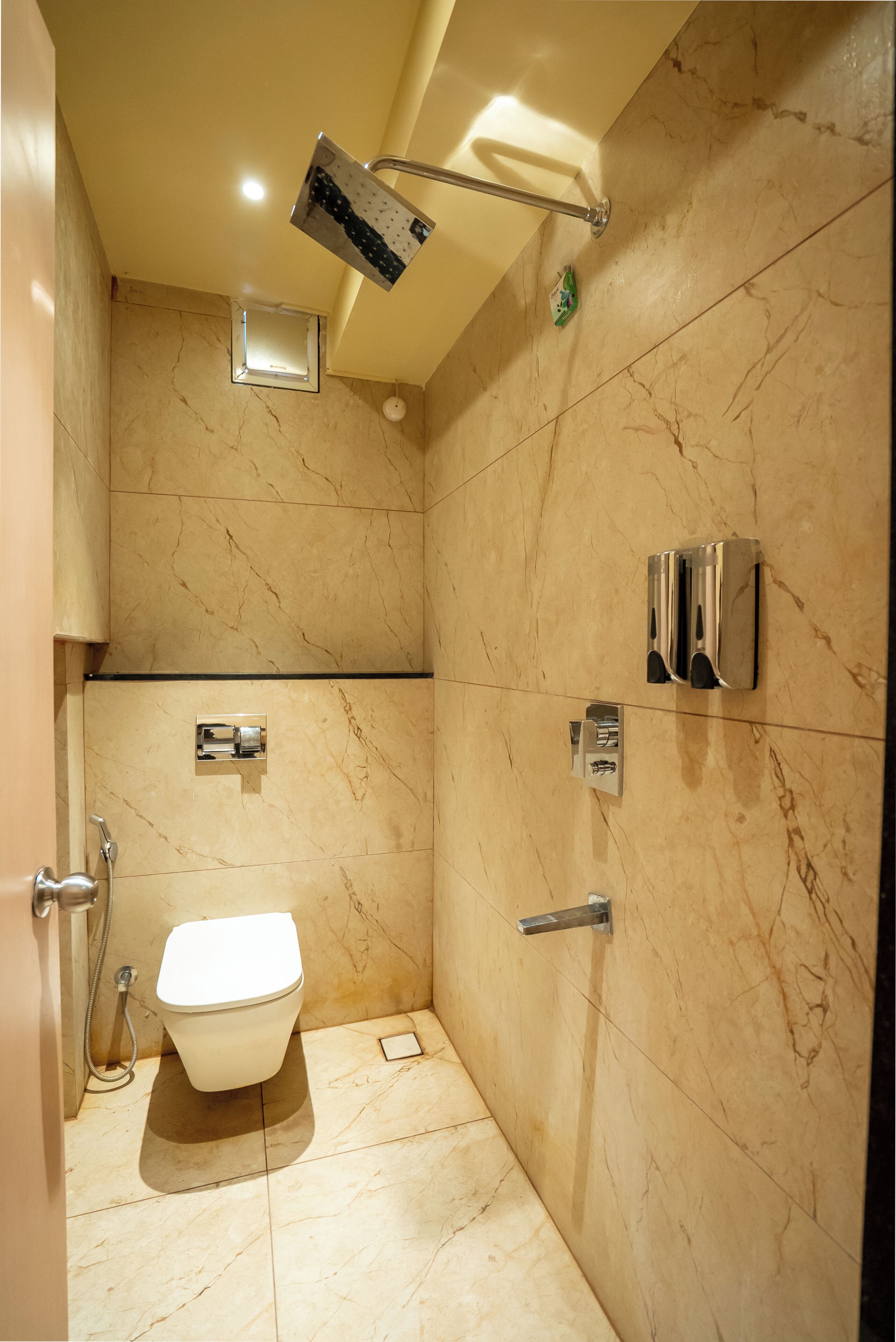 A bathroom with a toilet, a shower, and a towel rack.