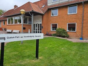 A brick building with a sign indicating 'Gudum Park - Hovedindgang - Reception.' - 1 Person Holiday Park Home in Lemvig (Lemvig)