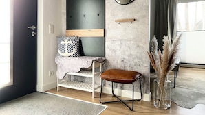 A modern living room with a built-in bench, a round mirror, and a small shelf.