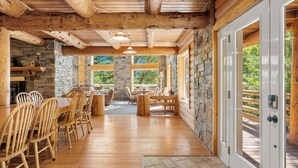 Un amplio comedor con muebles de madera y paredes de piedra.