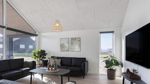Una sala de estar moderna con sofá, mesa de centro y plantas en macetas.