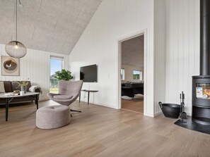 A modern living room with a fireplace, a comfortable seating area, and a view of the outdoors.