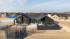 Zona residencial con casas modernas, un trampolín y una cancha de baloncesto.