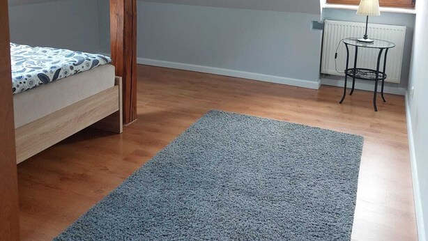 A room with a sloped ceiling, a bed, a small table with a lamp, and a window. - Apartment in Sopot Near Monte Cassino Street (Sopot)
