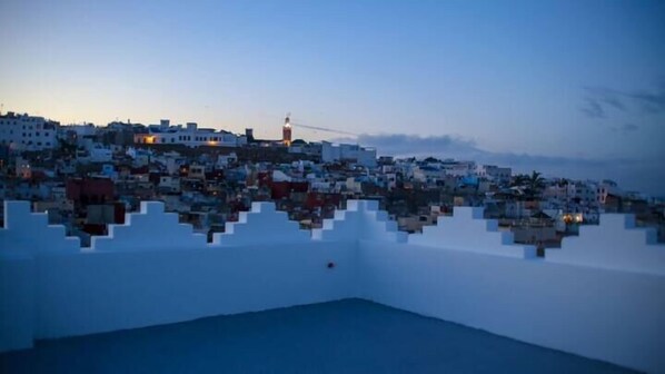 A coastal cityscape with buildings and a lighthouse. - Lalla radia (Tangier)