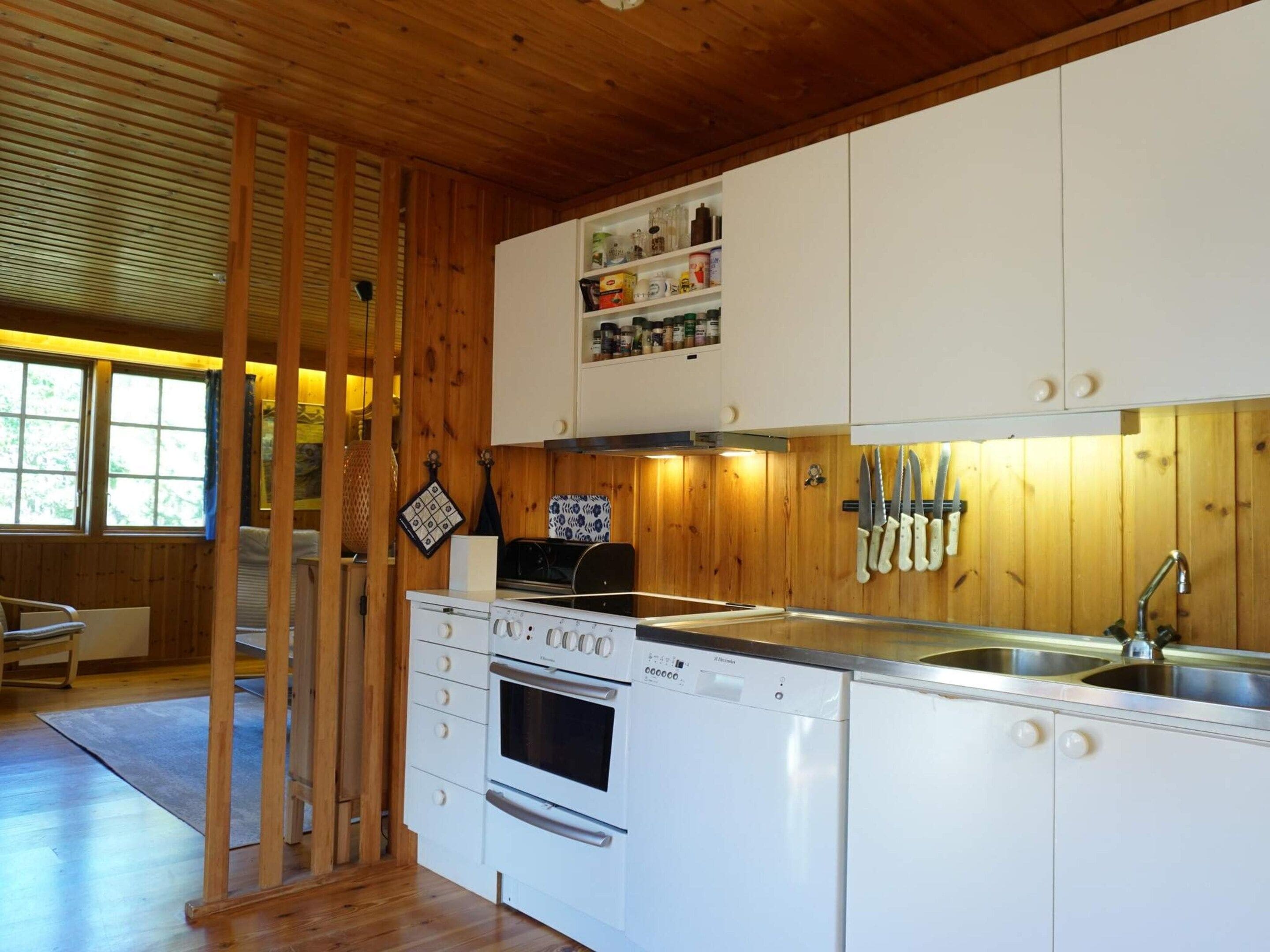 A kitchen with wooden cabinets, a built-in oven, a sink, and a stove.