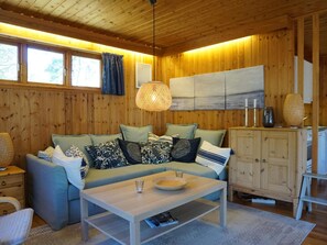 A cozy room with a sofa, a coffee table, and a cabinet.