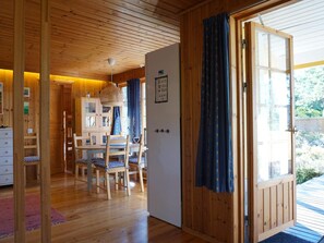 A wooden interior with a dining area, a white door, and a view of the outdoors. - 6 Person Holiday Home in Stromstad (Stromstad)