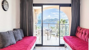 A room with a bed, a sofa, and a balcony with a table and chairs. - Charming Flat With sea View - 1BR - 2P - Bocca (Cannes)