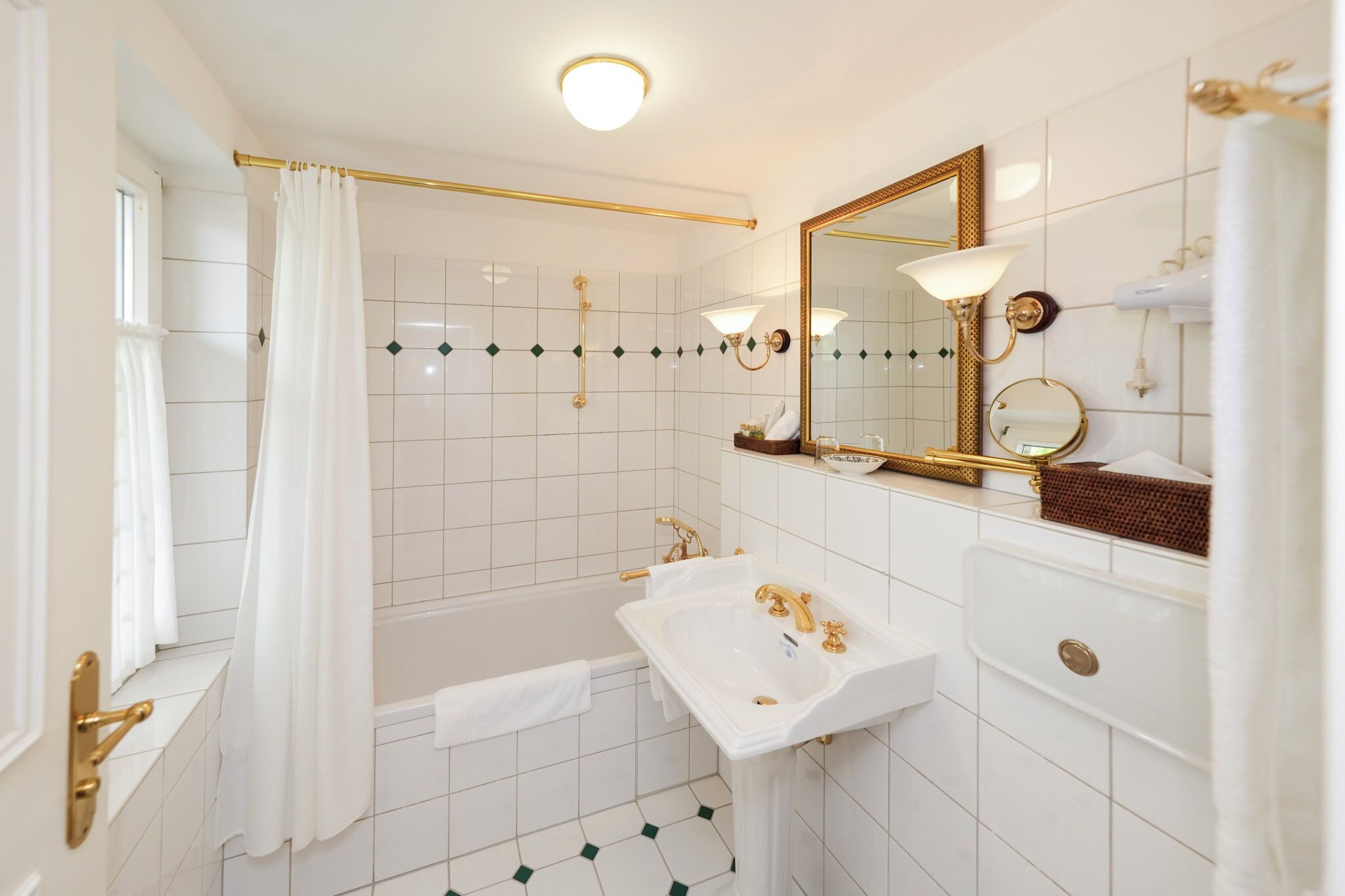 A bathroom with a bathtub, a sink, a mirror, and a shower curtain.