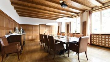 Ein Essbereich mit Holztisch und -stühlen, einer Holzausstattung an der Decke und großen Fenstern.