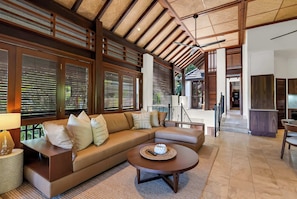 A modern living room with a sofa, coffee table, and a view of the outdoor area.