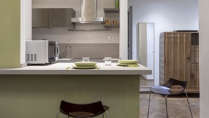 Una cucina moderna con isola centrale, mobili integrati e cappa aspirante in acciaio inossidabile.