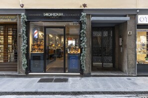 Un escaparate con un letrero que dice "MONDIAL BARBER" y una exhibición de herramientas de barbero en su interior.