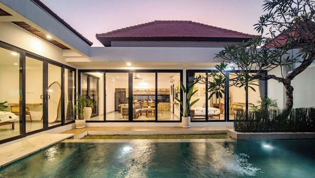 A modern house with a swimming pool, large glass doors, and a dining area. - Villa CanSavina - 3 Rooms - Center Of Seminyak (Bali)