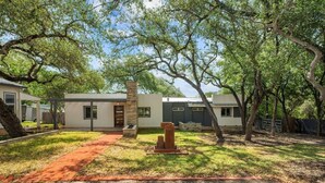 A modern two-story house with a covered patio, a stone pillar, and a red brick pathway. - Lakefront Retreat: Private Dock | King Bedrooms (Burnet County)