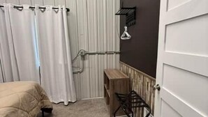 Un dormitorio con cama, escritorio, silla y armario.