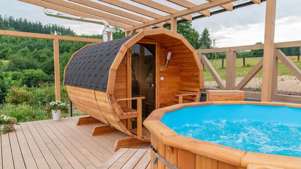 A wooden hot tub and a sauna on a wooden deck with a view of a forest. - Cottage in Duszniki Near Ski Slopes (Szczytna)