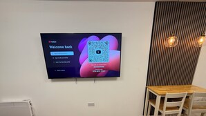 A flat-screen TV mounted on a wall displaying a YouTube Kids sign-in screen. - Modern Studio with private Bathroom & Kitchenette in 3 bed apartment (London)