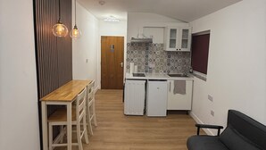 A modern kitchen with white cabinets, a built-in oven, and a patterned backsplash. - Modern Studio with private Bathroom & Kitchenette in 3 bed apartment (London)