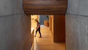 Ein modernes Interieur mit Holzboden, Betonwänden und einer Holzbalkendecke.