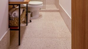 Een moderne badkamer met een glazen douchecabine, een wit wastafelmeubel en een toilet.
