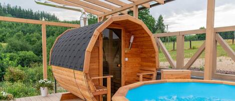 A wooden hot tub with a wooden deck and a covered seating area.