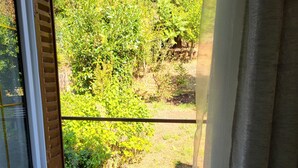A room with a window overlooking a garden. - Large suite with access to living room, terrace, garden - Thiers center, train station (Thiers)