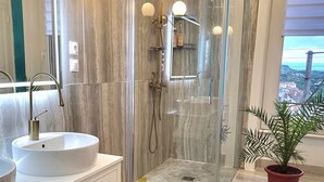 A modern bathroom with a glass-enclosed shower, a white sink, and a large mirror. - Large suite with access to living room, terrace, garden - Thiers center, train station (Thiers)