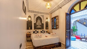 Een slaapkamer met een groot bed, een decoratieve wand en uitzicht naar buiten.
