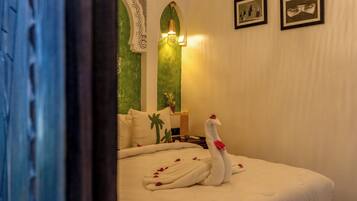 Une chambre d’hôtel avec un lit, un cygne décoratif et un mur vert.