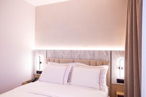 A hotel room with a bed, nightstands, and wall-mounted lighting. - Tris3 Hotel (Orikum)
