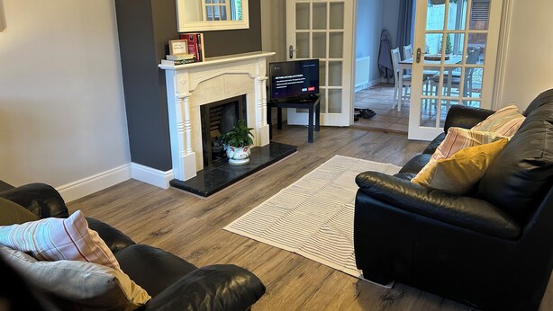Una sala de estar con chimenea, televisor y sofá.
