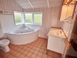 A bathroom with a freestanding bathtub, a toilet, and a sink.