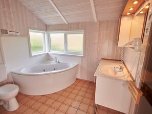 A bathroom with a freestanding bathtub, a toilet, and a sink. - 4 Star Holiday Home in Friedrichkoog (Friedrichskoog)