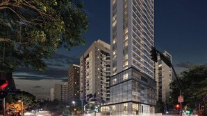 Een modern hooggebouw met meerdere verdiepingen, grote ramen en een opvallend hoekontwerp.