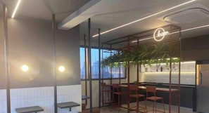 Zona de bar moderna con letrero de neón, asientos y vistas de la ciudad.