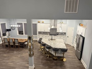 A modern kitchen with a central island, white cabinetry, and stainless steel appliances. - Beautiful Escape, Mins from Carowinds & Lake Wylie (Charlotte)